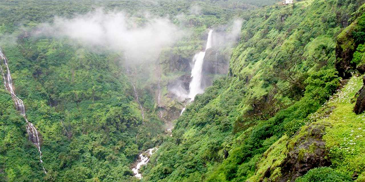 Misty morning valley views waterfall landscape with Sahyadri mountain fog at sunrise in Mahabaleshwar, Maharashtra